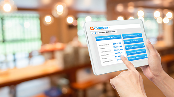 Person in a coffee shop looking at their Mapline dashboard on a tablet